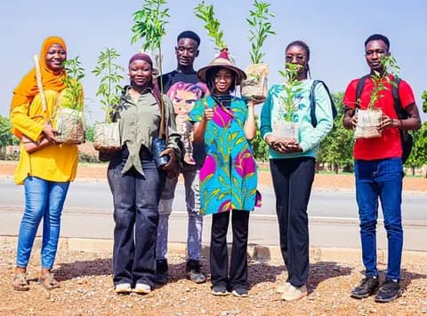 Jeunes membres tenant des plants d’arbres prêts à être mis en terre
