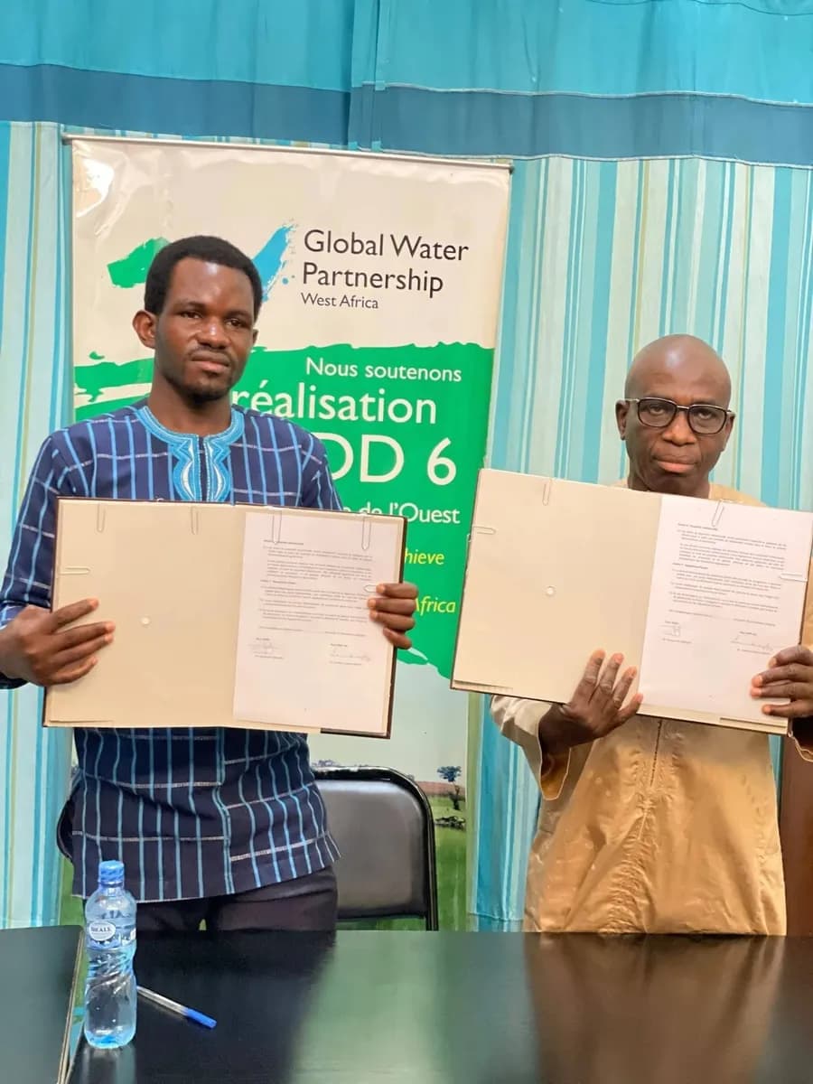 Les représentants de l’ACIEA et du GWP Afrique de l’Ouest présentent le protocole d’accord signé, devant une bannière du GWP